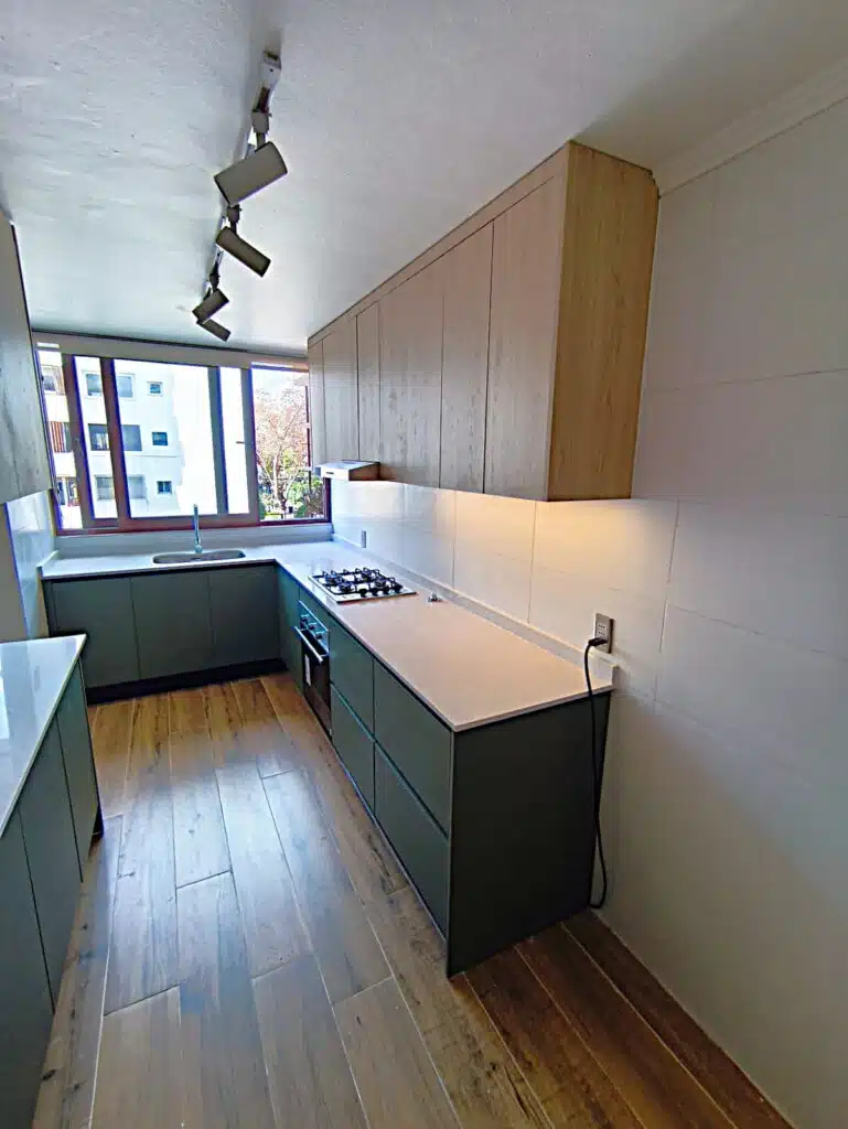 muebles a la medida para cocina moderna en tono verde y color madera mas cubierta de cuarzo